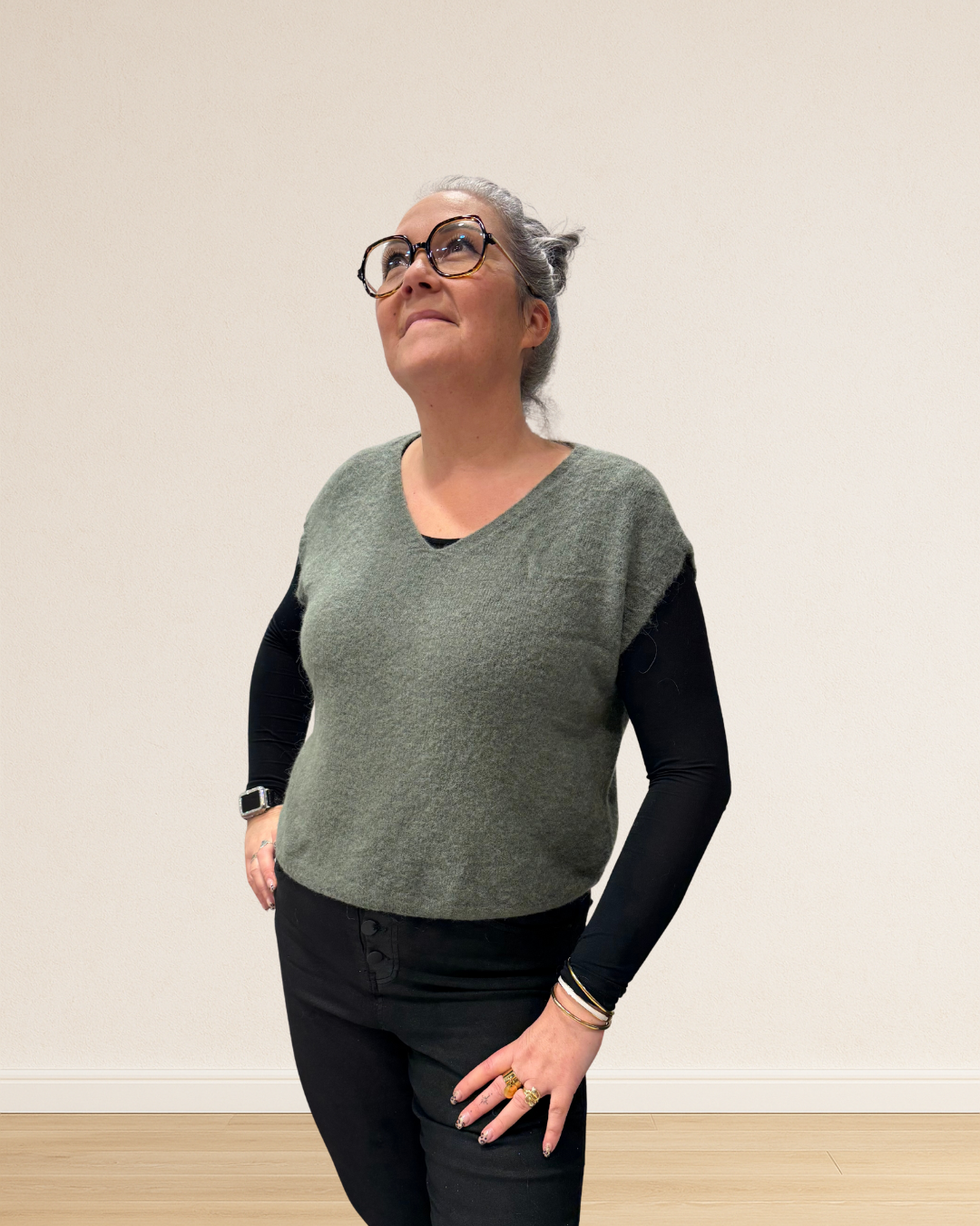 Pull sans manches porté sur une chemise pour un look tendance