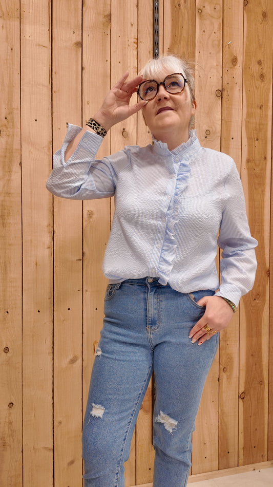 Chemise femme bleue à volants col montant, blouse élégante manches longues.