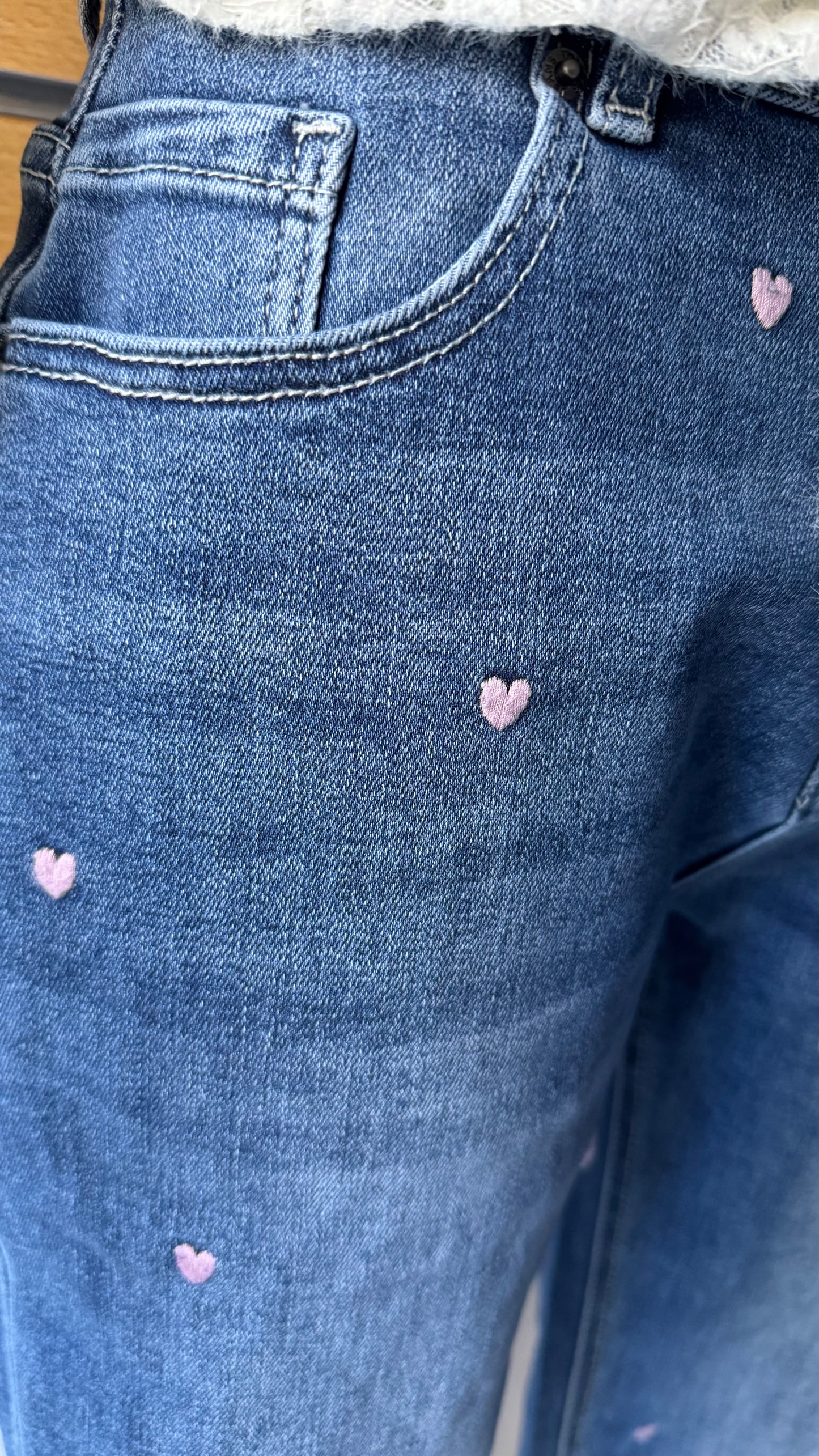 Détail petits cœurs brodés rose pâle sur jean femme