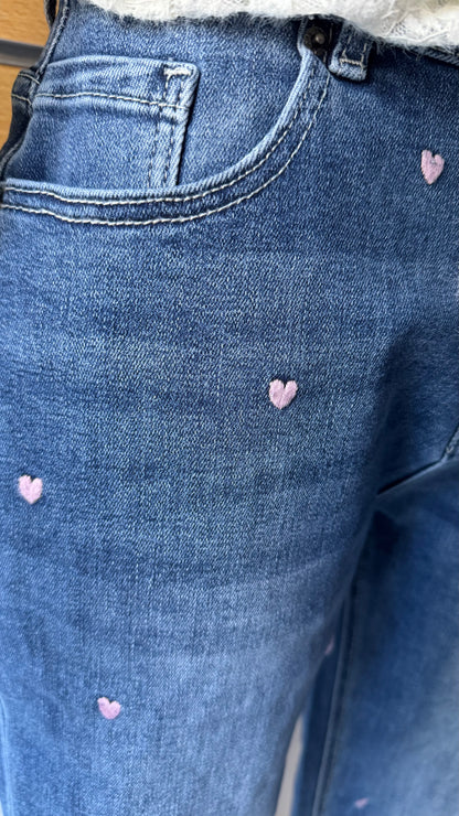 Détail petits cœurs brodés rose pâle sur jean femme