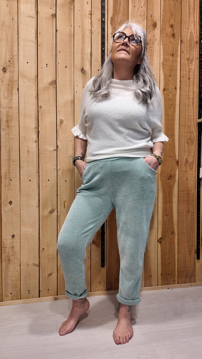 Femme portant un pantalon effet velours vert d’eau coupe droite 7/8 avec revers, taille élastique confortable.